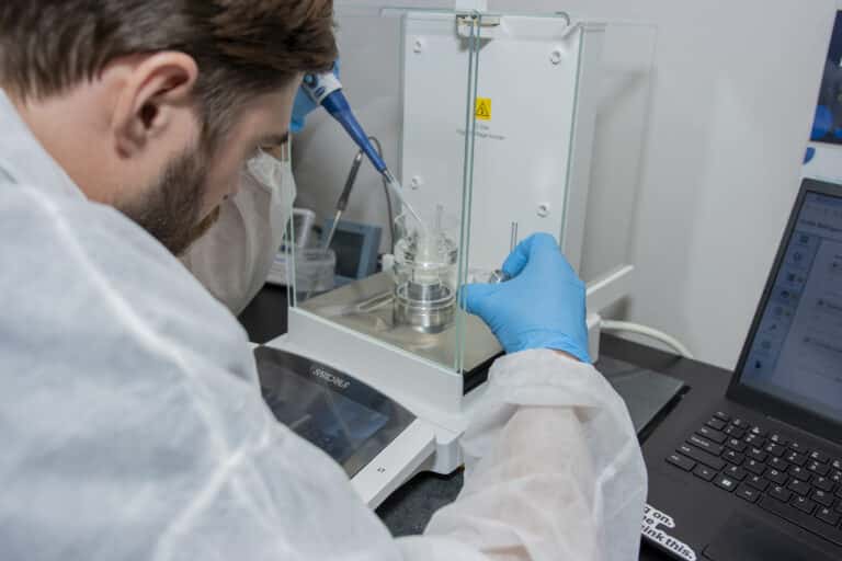 man in laboratory using pipette